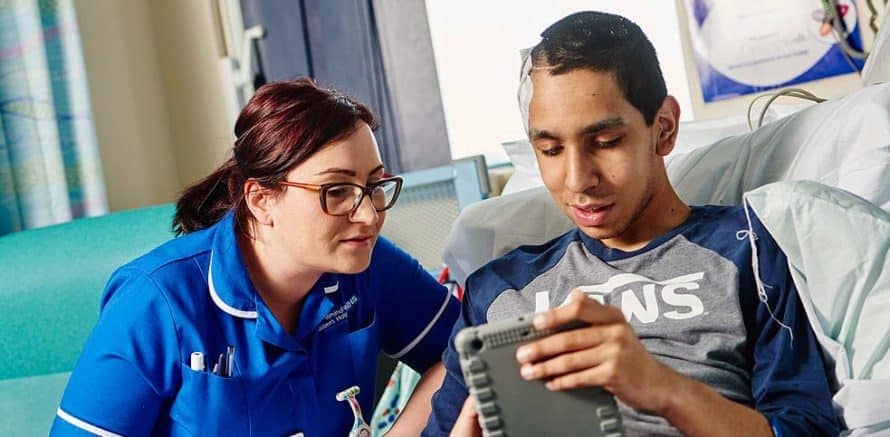 nurse with young boy in hospital bed