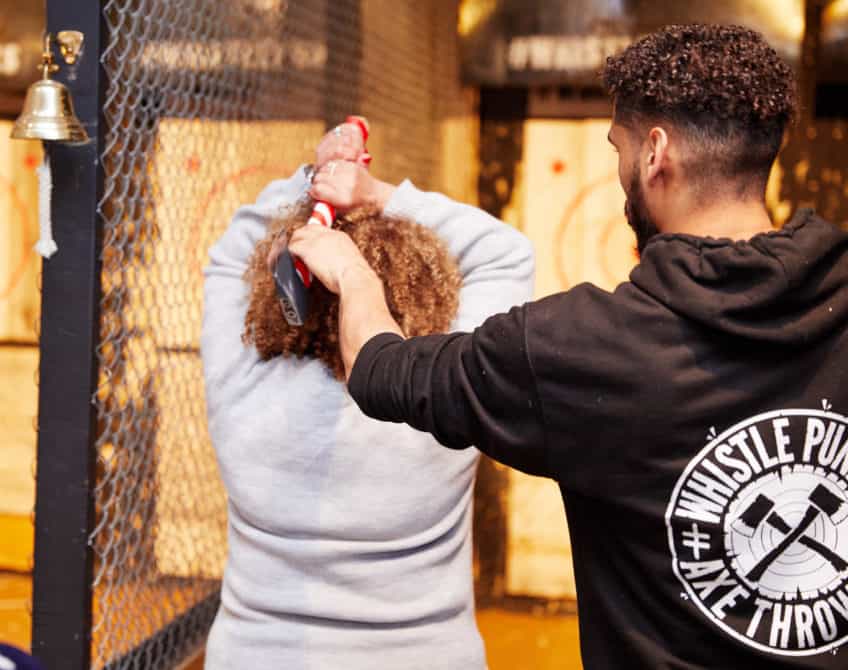 team member helping with axe throwing form