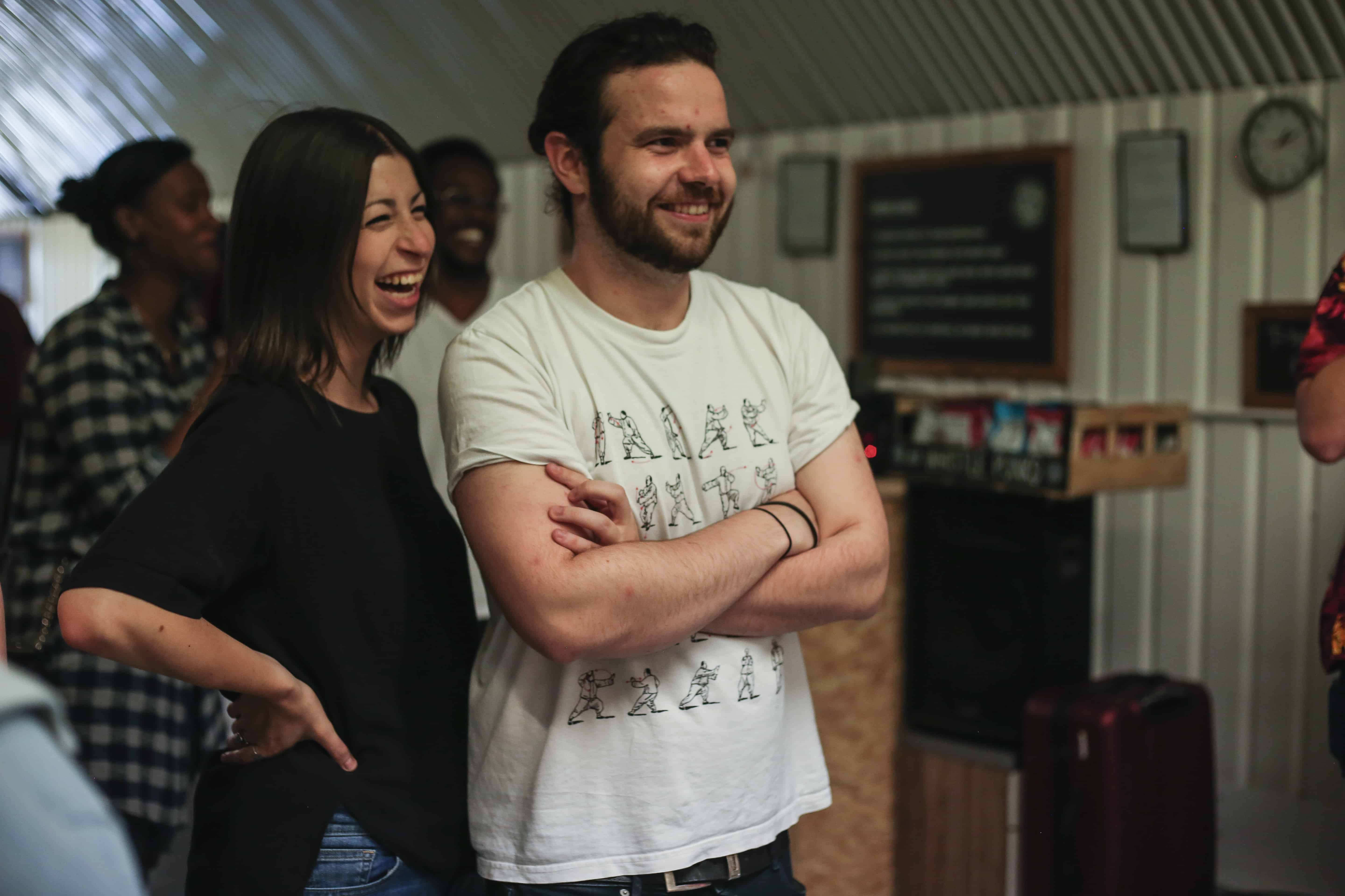 2 people watching friends throw axes