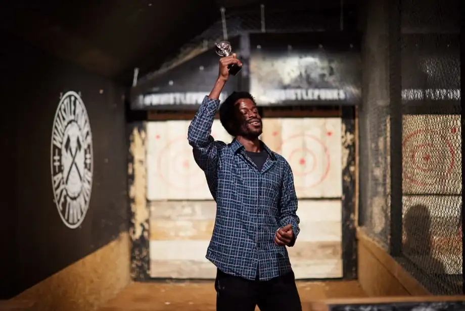 Man holding axe throwing trophy aloft